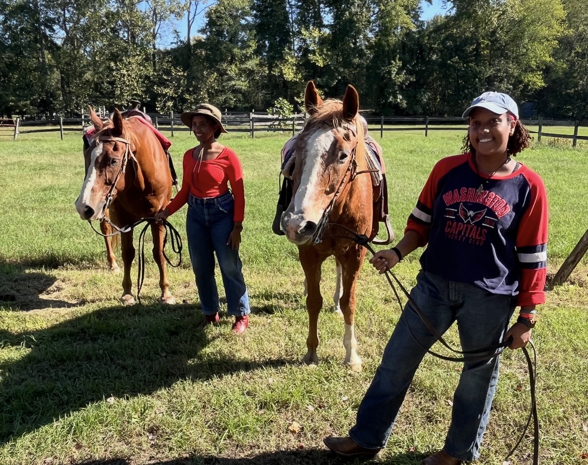 Two friends with their horses in an open pasture at The Educated Horsemen farm
